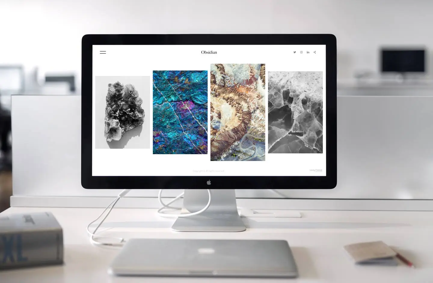 A desktop monitor on an office desk displaying a photography portfolio website