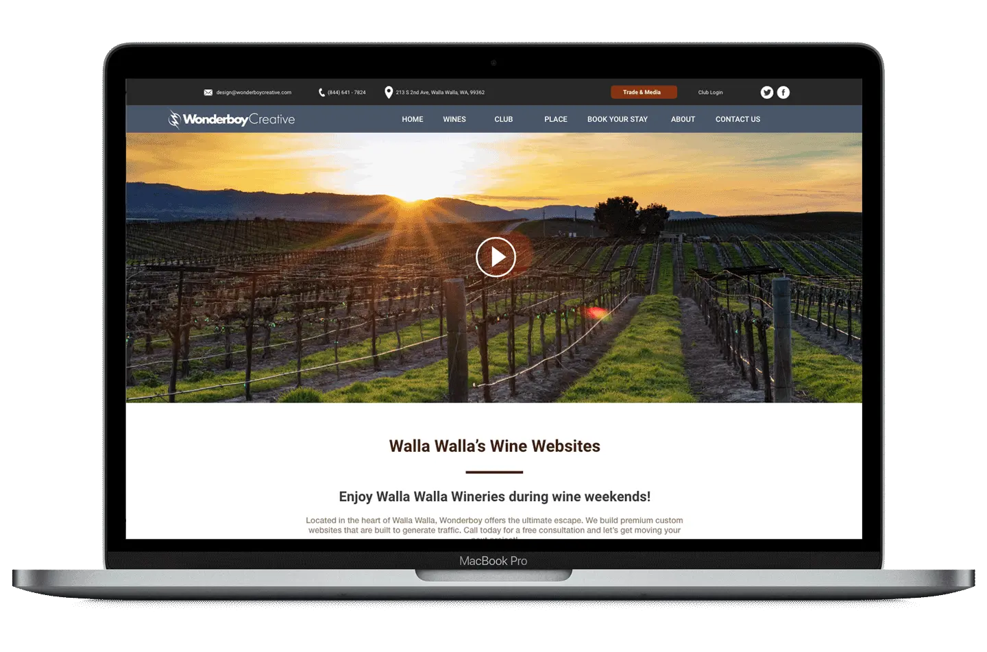 A laptop showing a Walla Walla wine website with a vineyard at sunrise across the header